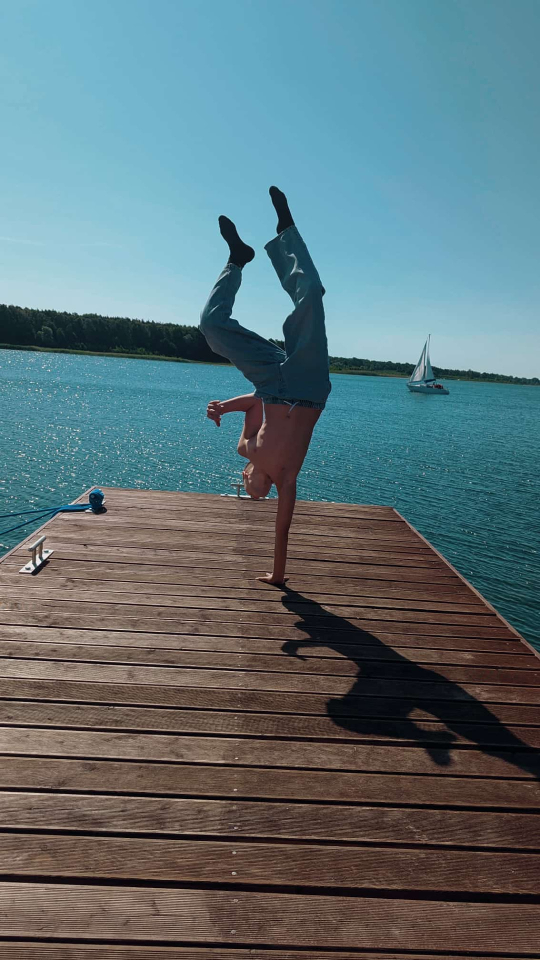 Peter, ASHEZ co-founder based in Europe, doing a one-handed handstand on a lakeside dock